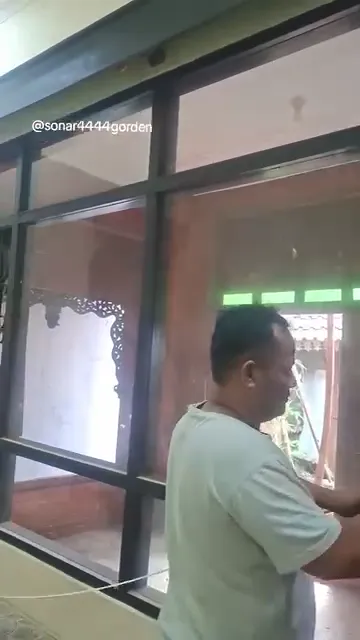 Teknisi Sonar Gorden mengukur jendela kaca lebar saat survei di Solo